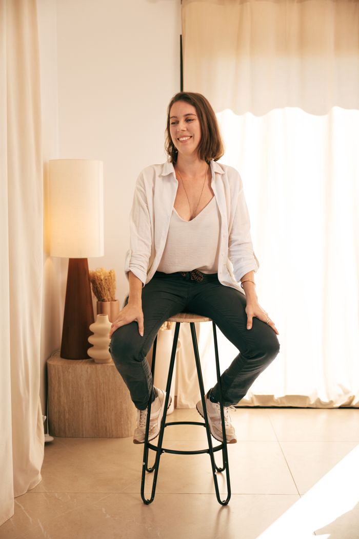 Gwendoline Meyer, souriante, assise sur un tabouret haut